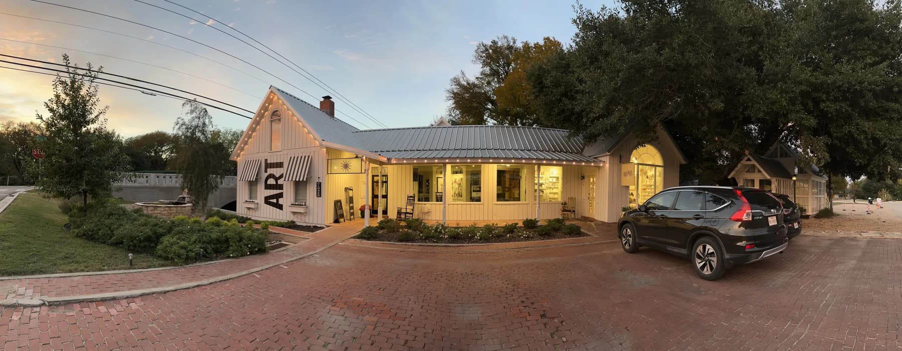 The Village Framer storefront and porch at dusk